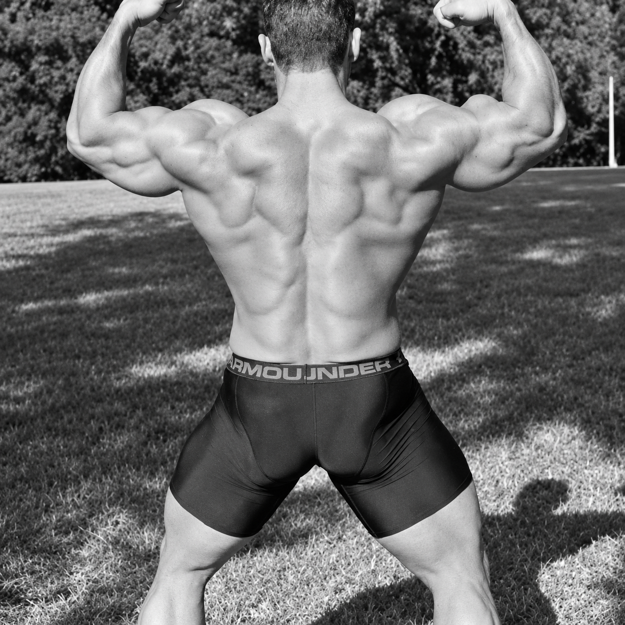 Adam posing outdoors in a black-and-white photograph