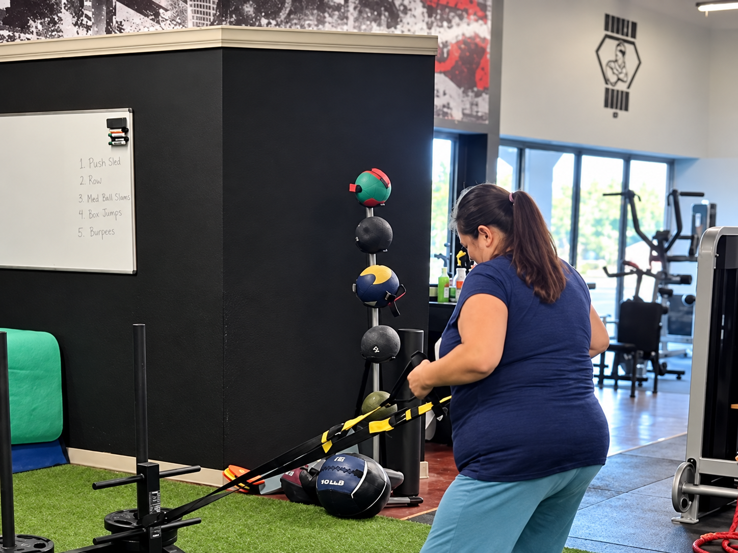 A woman performing a resisted rope exercise inside Bodies by Adam